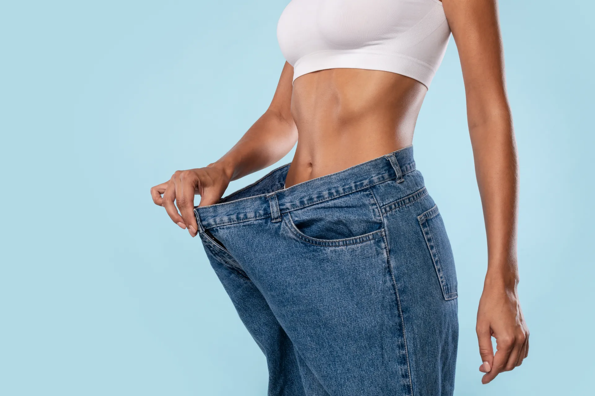 close up of woman pulling her old large loose jean utc